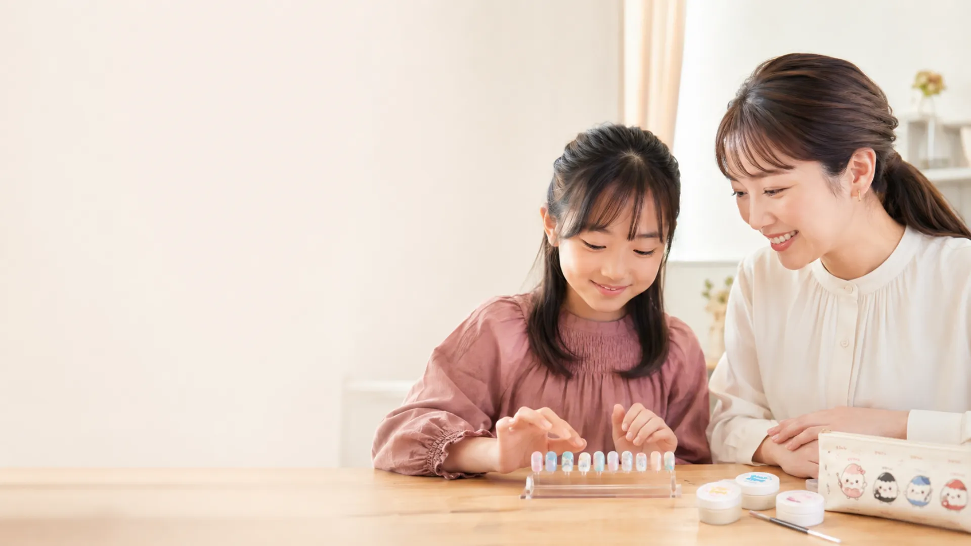 完成したネイルチップを見る先生と小学生