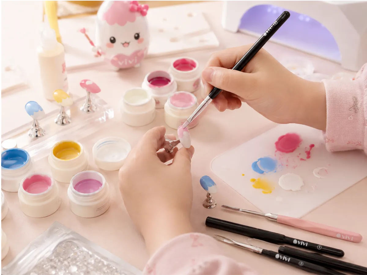 ネイルチップ制作で色を混ぜながら別の方法を試している子どもの手元
